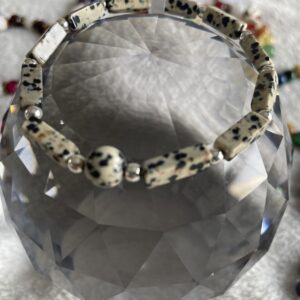 This Dalmatian Jasper bracelet has healing properties related to the digestive system, the nervous system, the muscles, tendons, and cartilage, and the balance of energies.  It is said to make the gut more reactive, limit stomach pain and other issues, heal sprains and gallstones, and relieve pain and arthritis.