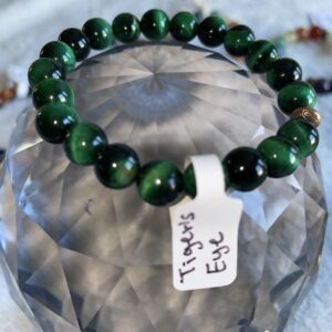 This green Tiger's Eye bracelet may assist the body by Regulating the circulatory system, soothing abdominal pain, and strengthening bones. It may also aid in improving eyesight and enhancing overall physical strength and endurance.