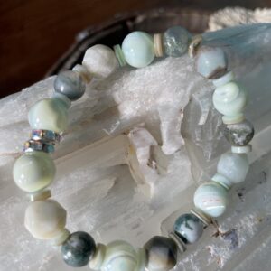 This Sea of Shells Energy Bracelet will assist your body to heal its Heart Chakra energy center, which governs your heart, thymus gland, lymph, immune system, lungs, bronchia, secondary circulatory system, arms, and hands. The green center connects us to unconditional love, compassion, and kindness; and balances our overall energy.